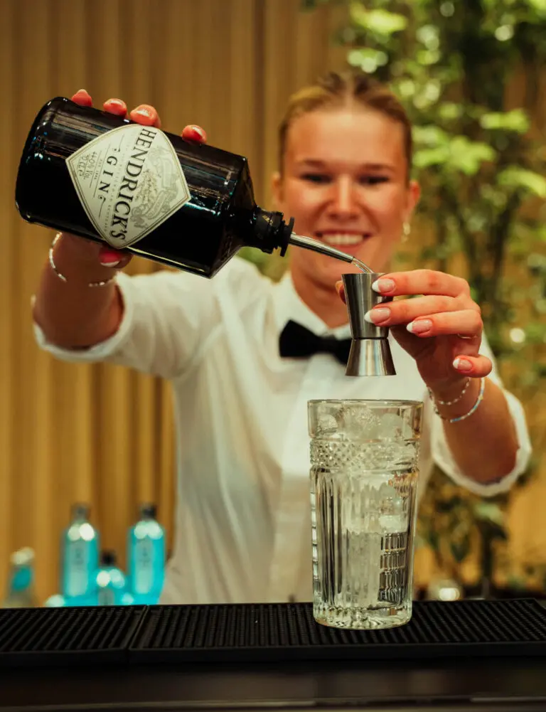 Professionel bartender laver cocktails i udlejningsbar til firmafest