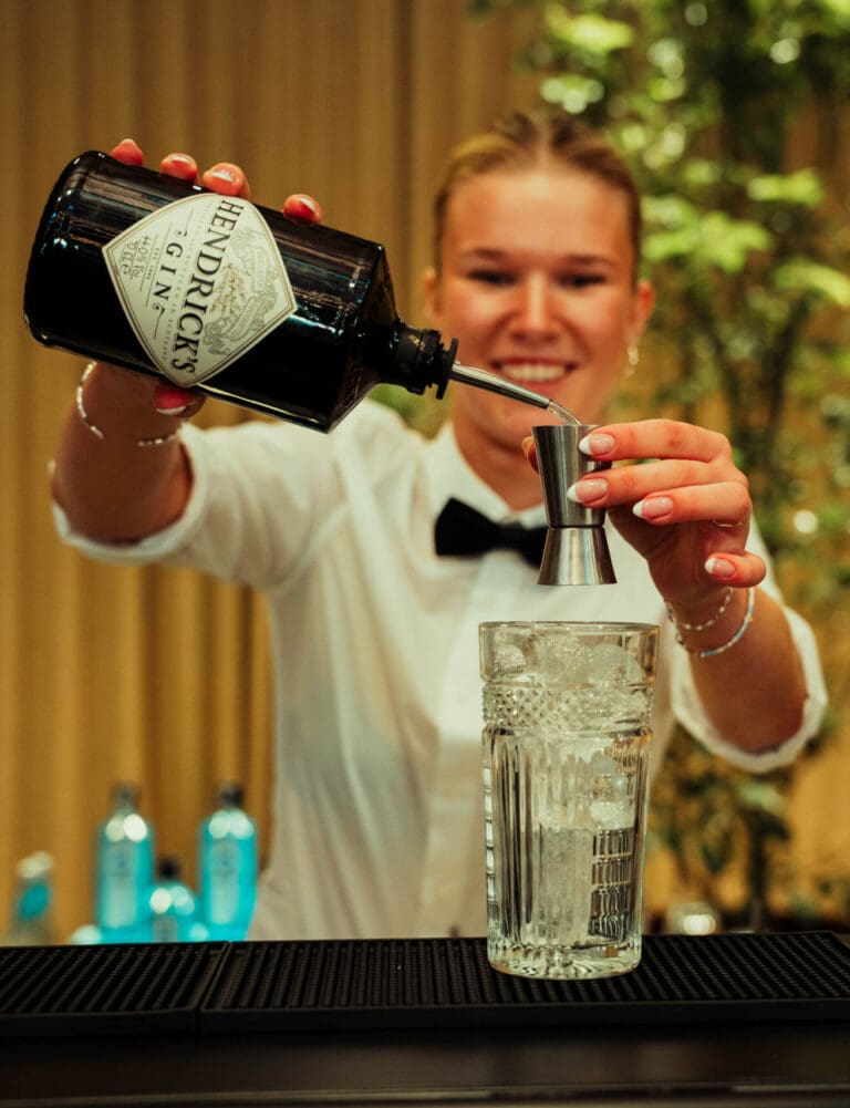 Professionel bartender laver cocktails i udlejningsbar til firmafest